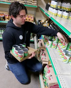 Local musician Anthony Worden stocks shelves at CommUnity Food Bank during his volunteer shift.